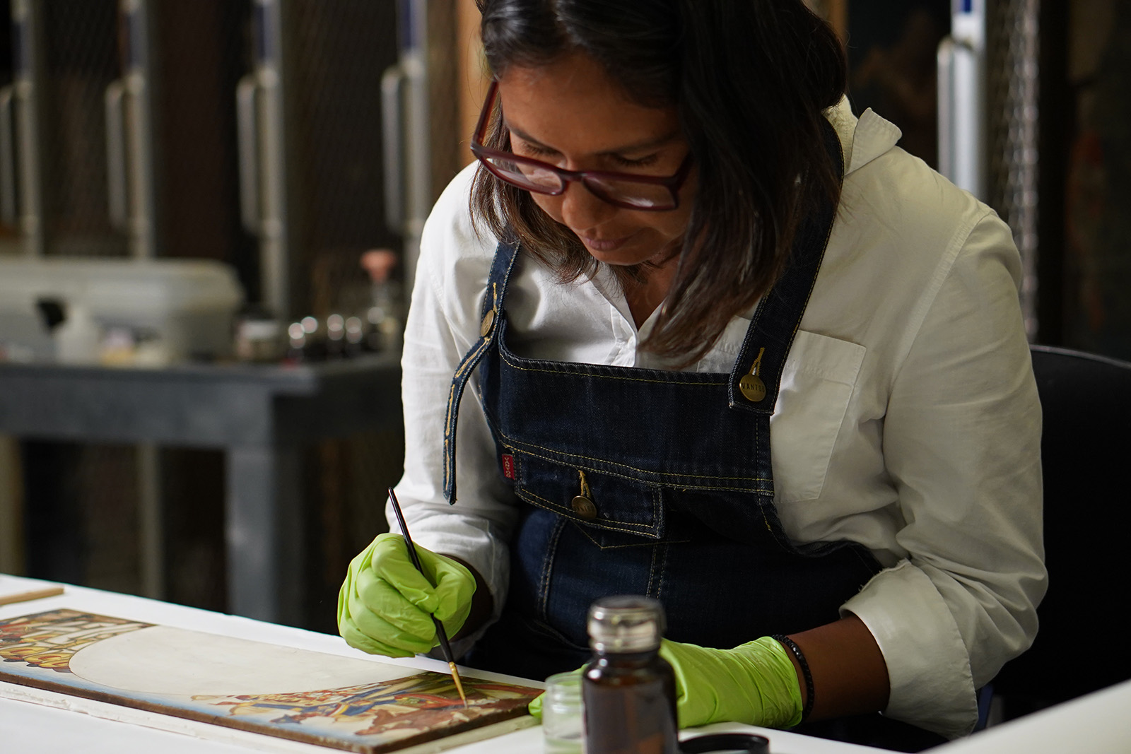 Silvia Manrique restoring a painting in the fourth-floor conservation center.